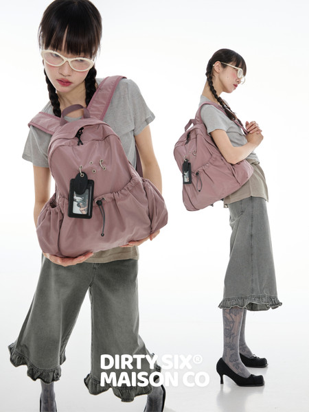 Pink backpack worn by a model on a white background