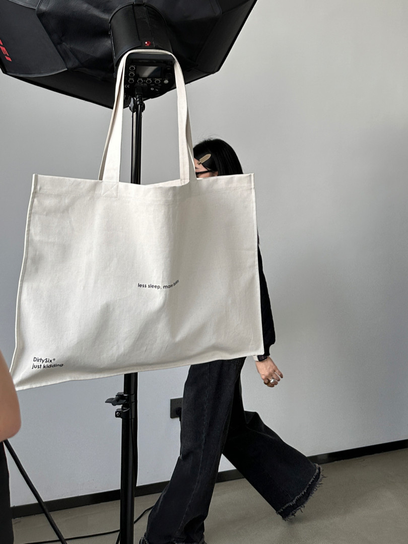 Large white canvas tote bag with printed text