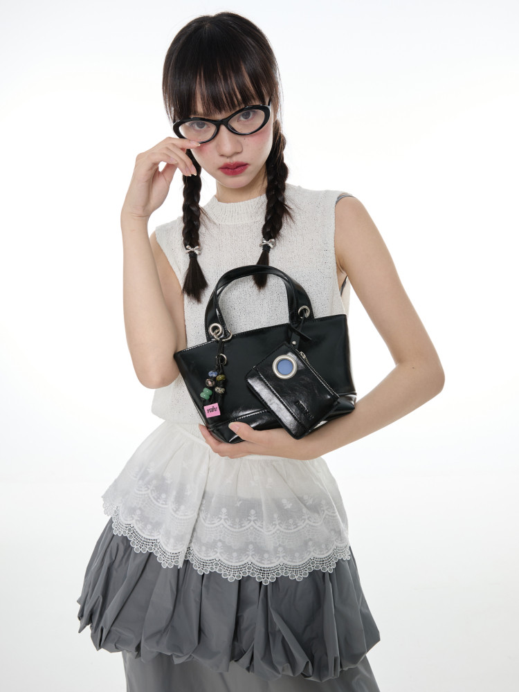 Black handbag with matching wallet held by a model