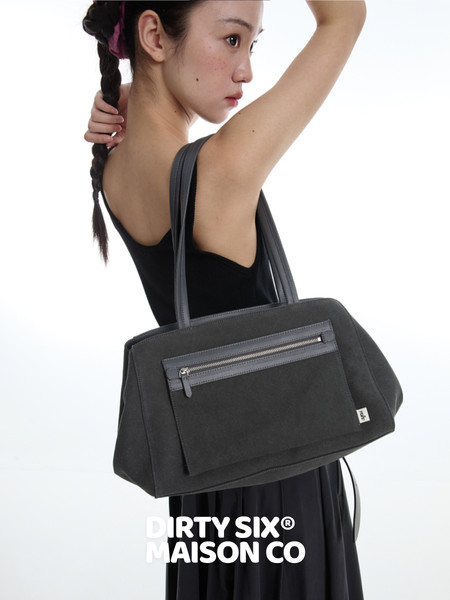 Black tote handbag worn by a model on a white background