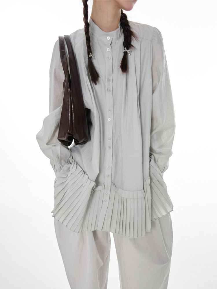 Light gray pleated long-sleeve button-up blouse worn on a model