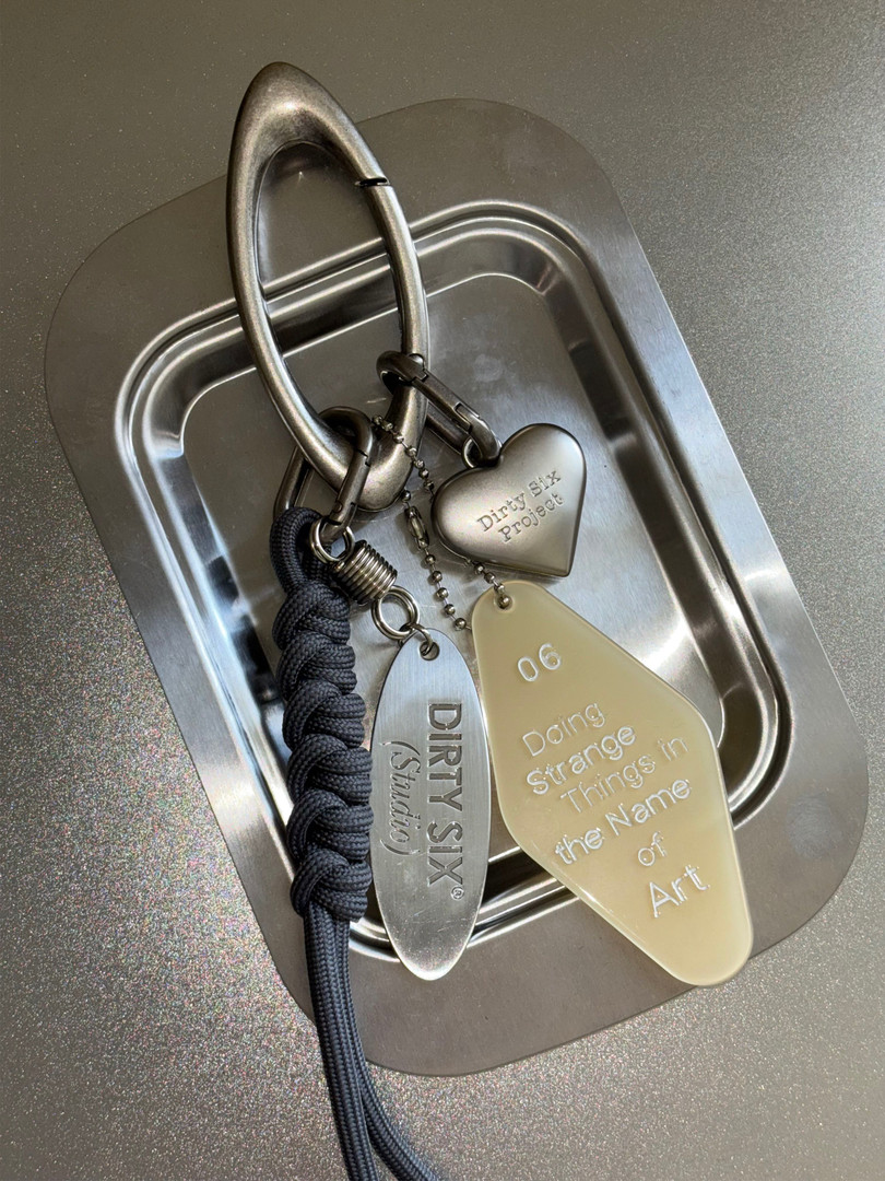 Metal keychain accessory with engraved pendants on a tray