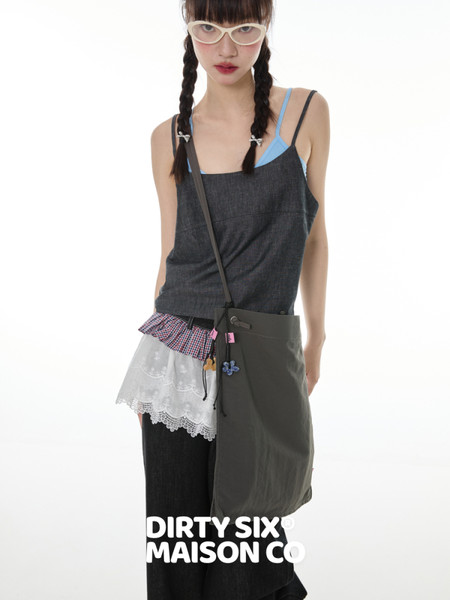 Fashion model wearing a layered dark camisole outfit with crossbody bag