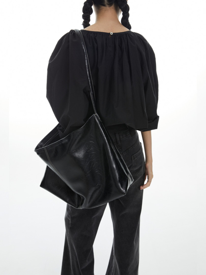 Black oversized leather shoulder bag worn with a black outfit