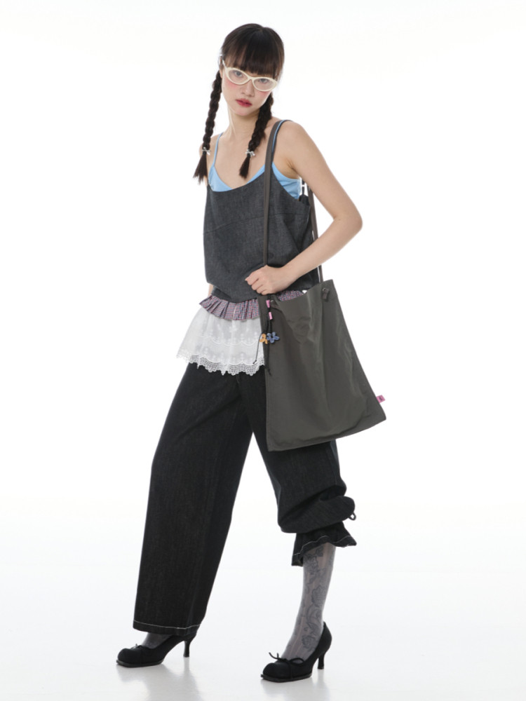 Fashion model wearing a layered edgy street-style outfit with a tote bag