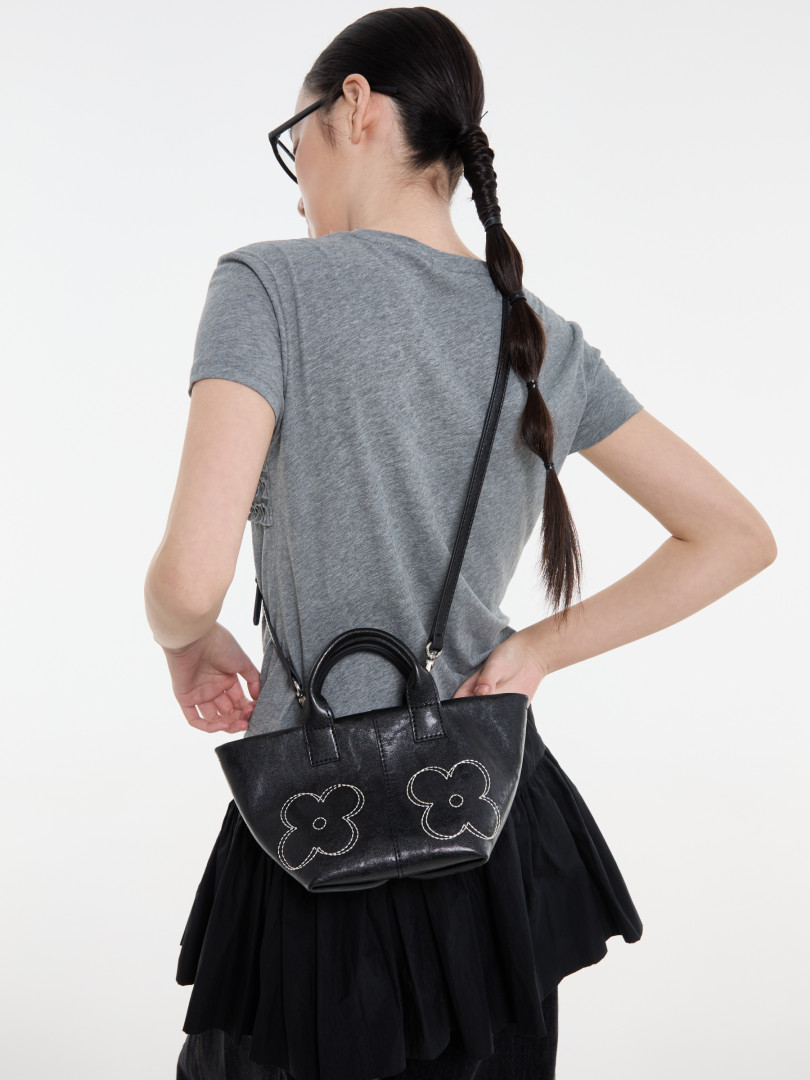 Black leather shoulder handbag worn by a model