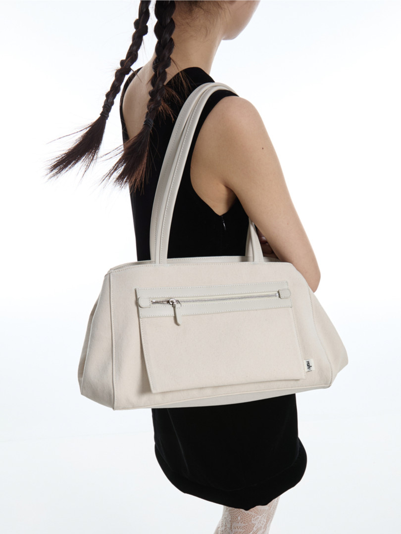 Light beige tote handbag worn on a model