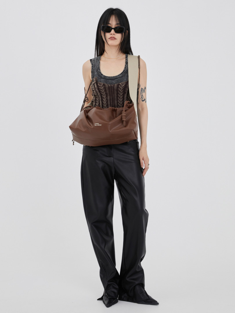 Brown slouchy shoulder bag worn by a model with a dark outfit