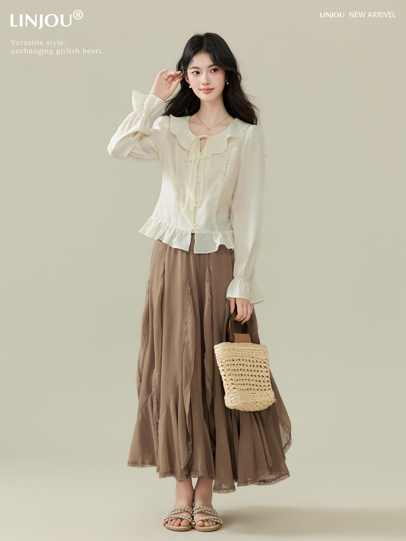 Model wearing a cream ruffled blouse with a brown midi skirt and straw handbag