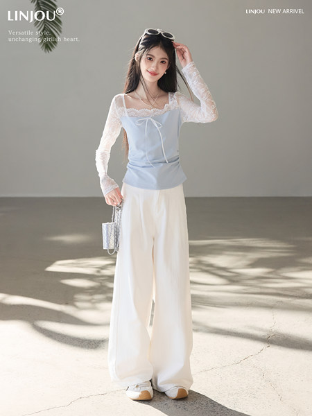 Model wearing a light blue lace long-sleeve top with white wide-leg pants