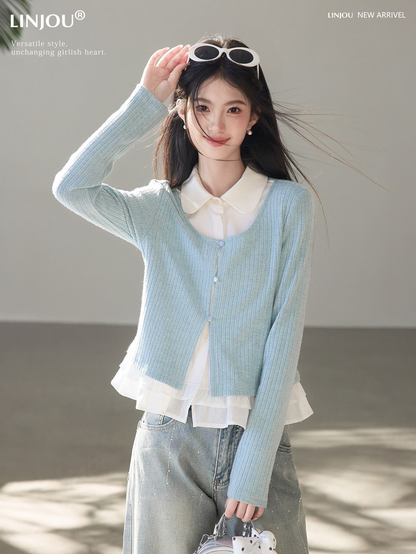 Model wearing a light blue ribbed cardigan over a white blouse with jeans