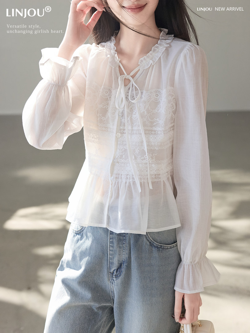 White sheer ruffled lace blouse worn by a model with blue jeans