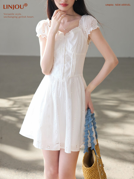 Model wearing a white eyelet short-sleeve dress with a flared skirt