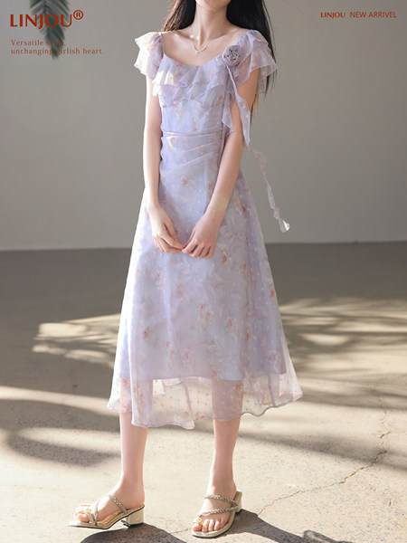Model wearing a pastel floral midi dress with ruffled sleeves
