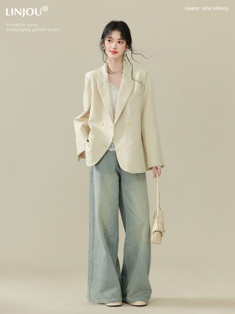 Model wearing a cream blazer with wide-leg jeans and a small shoulder bag