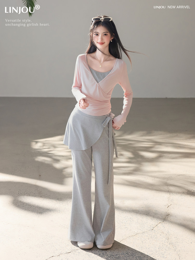 Woman modeling a pink wrap top with gray wide-leg pants
