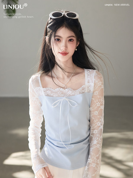 Woman wearing a light blue lace long-sleeve top with a bow detail