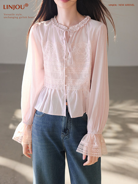 Model wearing a light pink lace-trim long-sleeve blouse with denim jeans