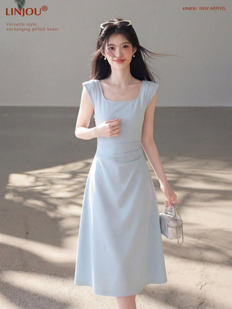 Model wearing a light blue sleeveless midi dress with a small handbag