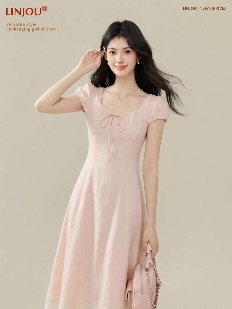 Model wearing a light pink short-sleeve dress with a bow detail