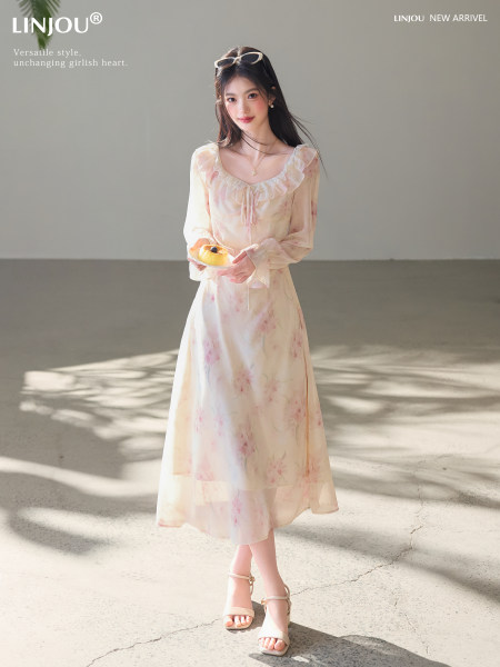 Model wearing a light floral long-sleeve midi dress and beige heeled sandals