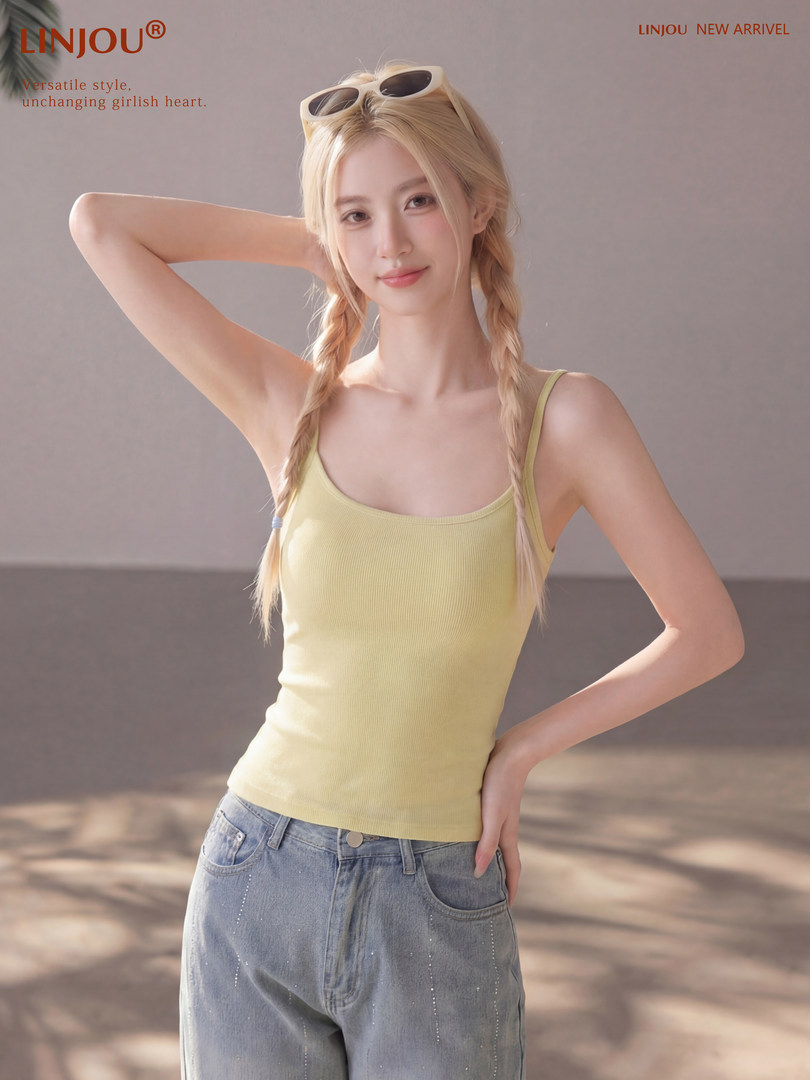 Blonde model wearing a light yellow tank top and jeans with sunglasses on head