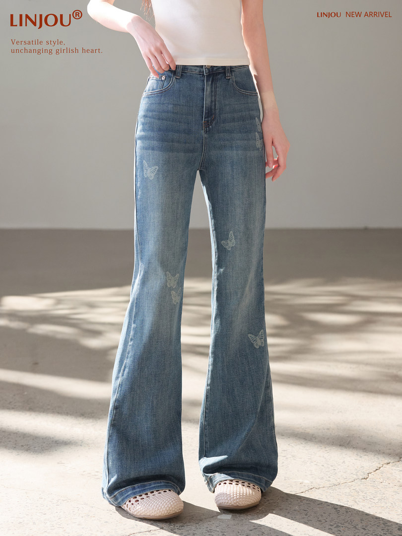Model wearing blue flared jeans with butterfly print and white top