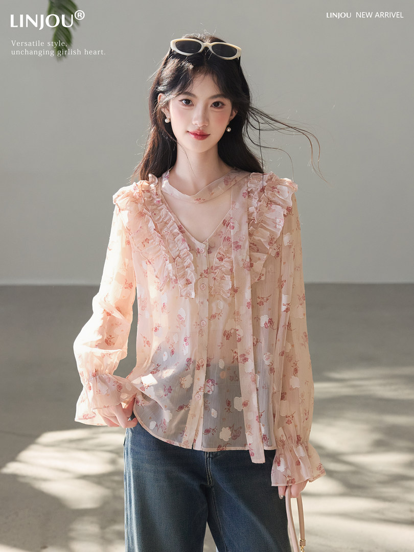 Model wearing a sheer floral ruffle blouse with long sleeves