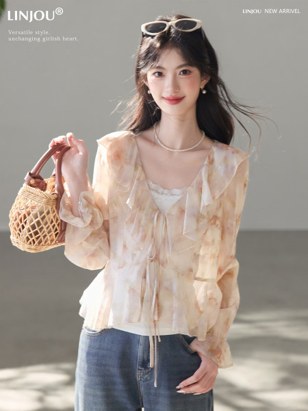 Model wearing a sheer floral tie-front blouse with jeans and a woven handbag