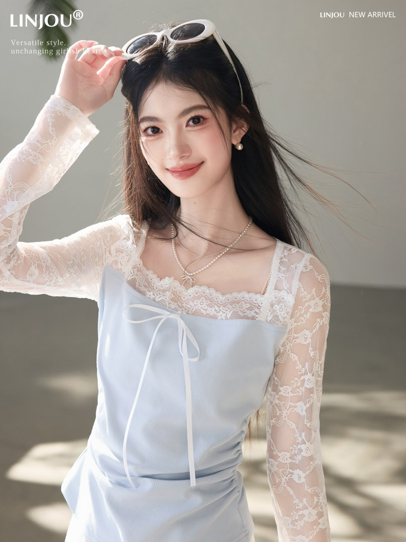 Model wearing a light blue lace long-sleeve dress with bow detail