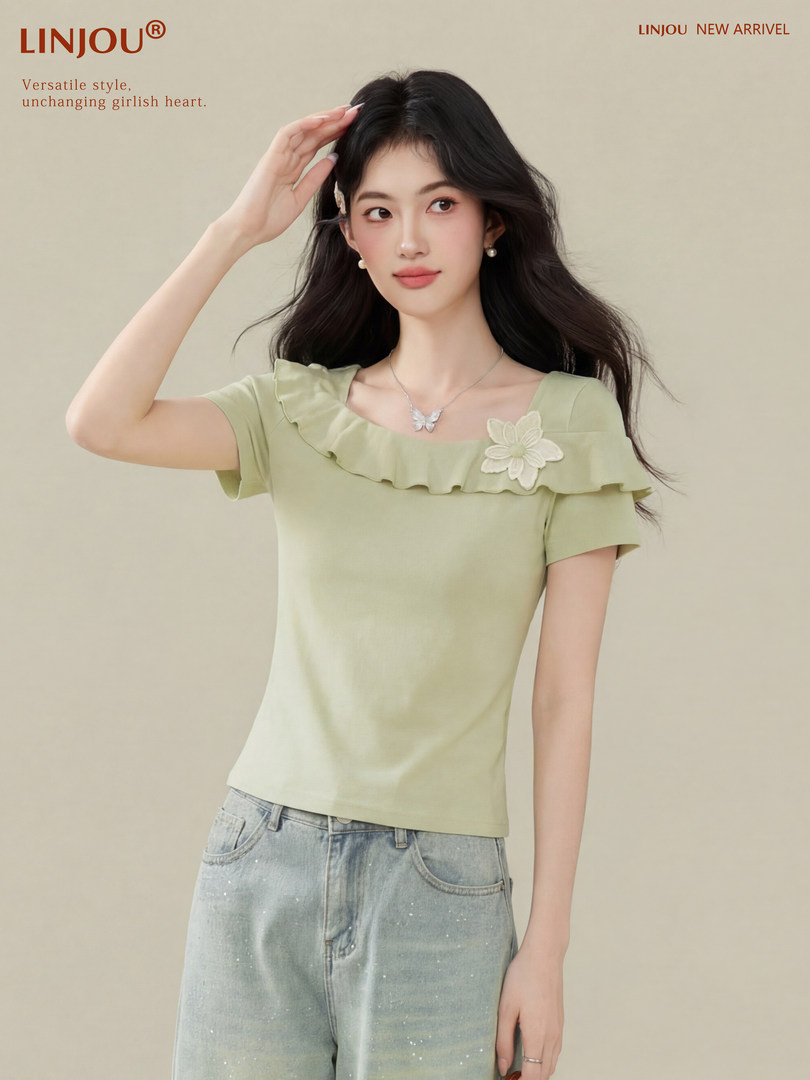 Model wearing a light green short-sleeve ruffled top with floral detail