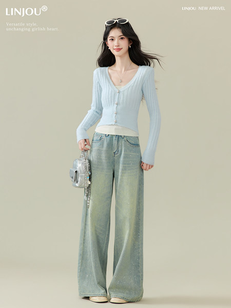 Model wearing a light blue ribbed cardigan and wide-leg jeans with a silver handbag
