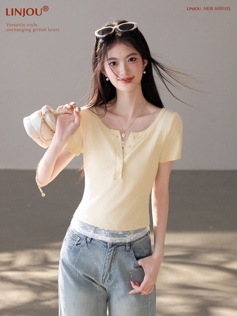 Model wearing a pale yellow short-sleeve button-front top with jeans