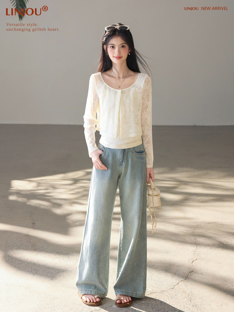 Model wearing a cream lace long-sleeve top with wide-leg light blue jeans