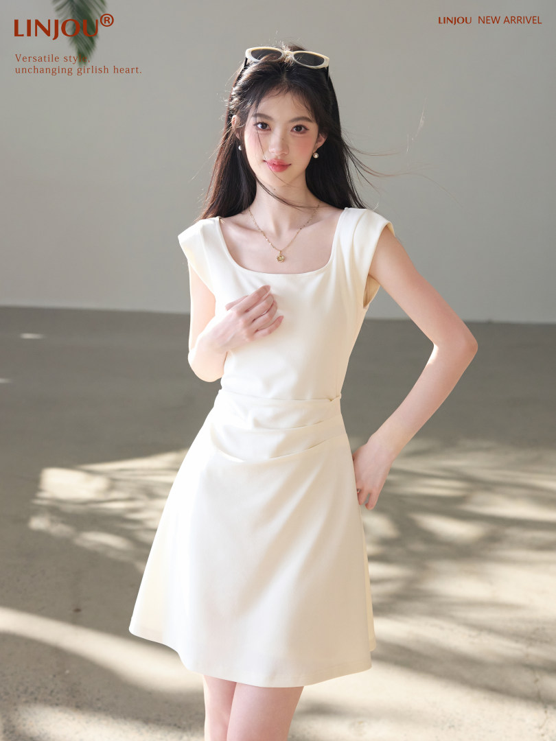 Model wearing a white sleeveless dress with a flared skirt