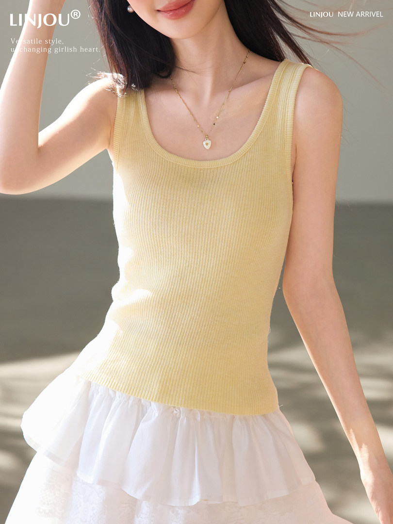 Woman wearing a pale yellow ribbed tank top with a white skirt