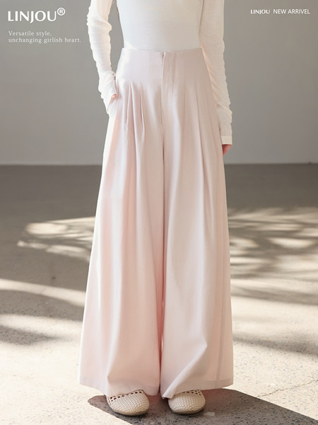 Model wearing light pink high-waisted wide-leg trousers