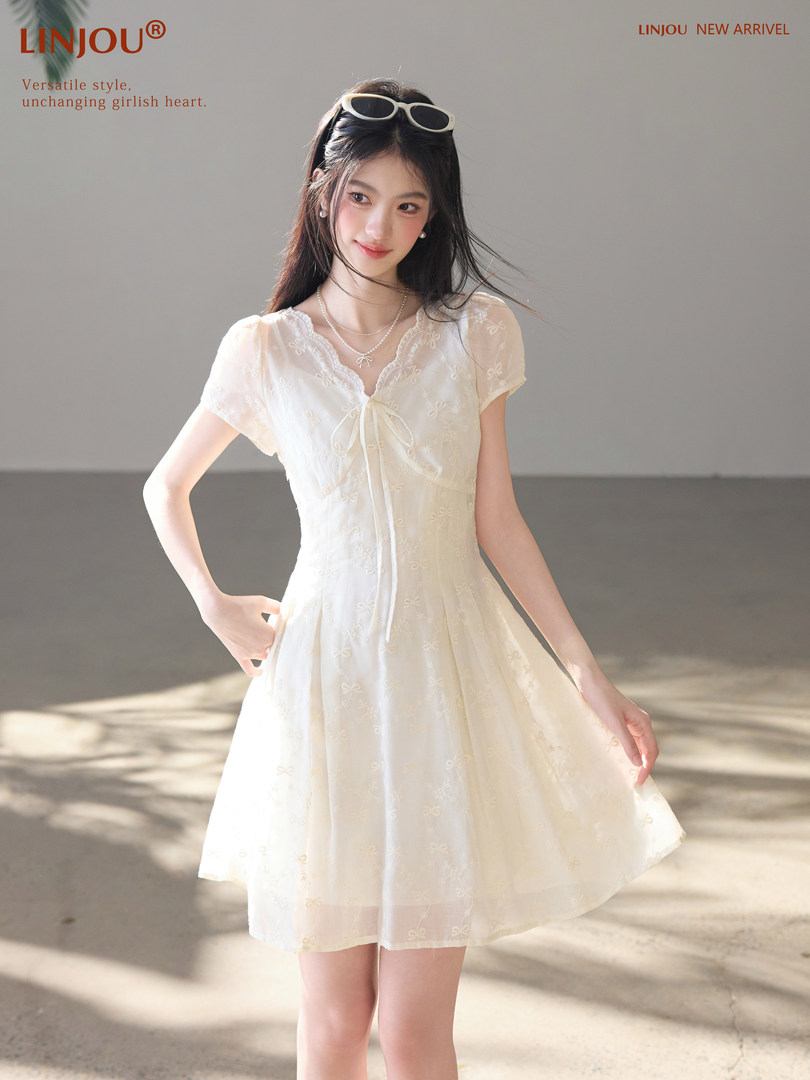Woman wearing a white short-sleeve dress with bow detail
