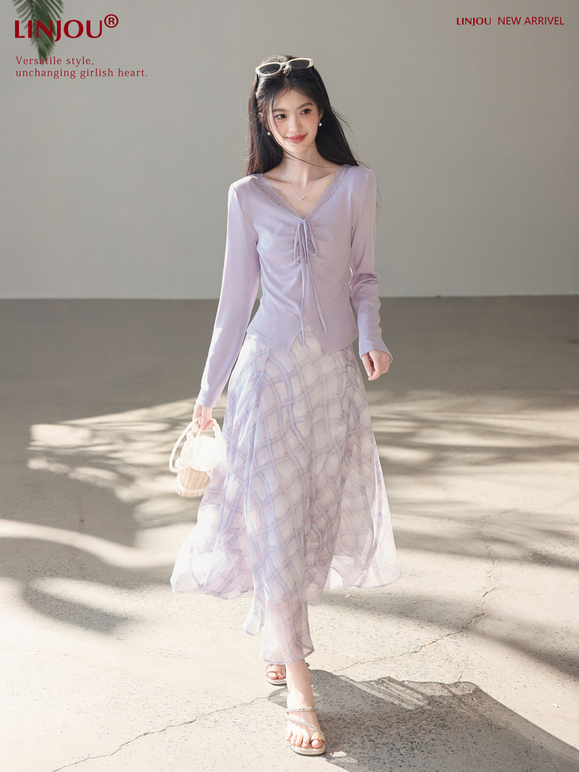 Model wearing a lavender long-sleeve top with a sheer plaid skirt