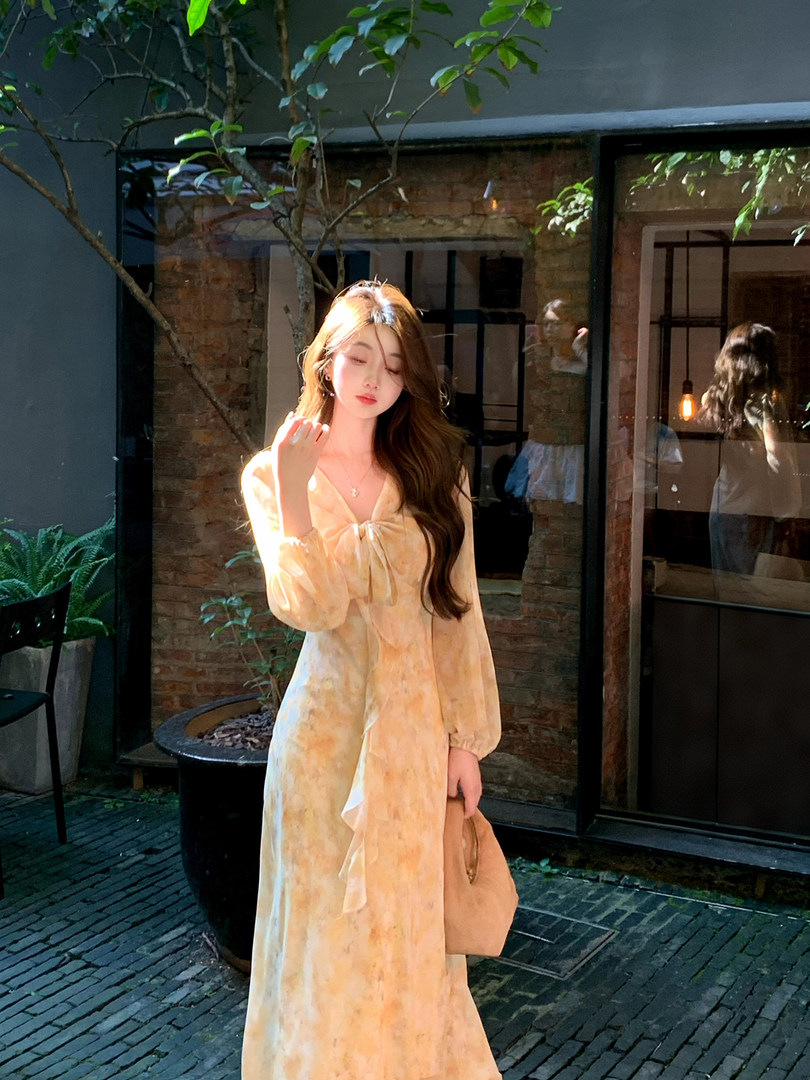 Light yellow floral long dress worn by a model outdoors