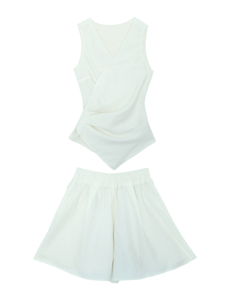 White sleeveless top and matching skirt laid flat on a white background