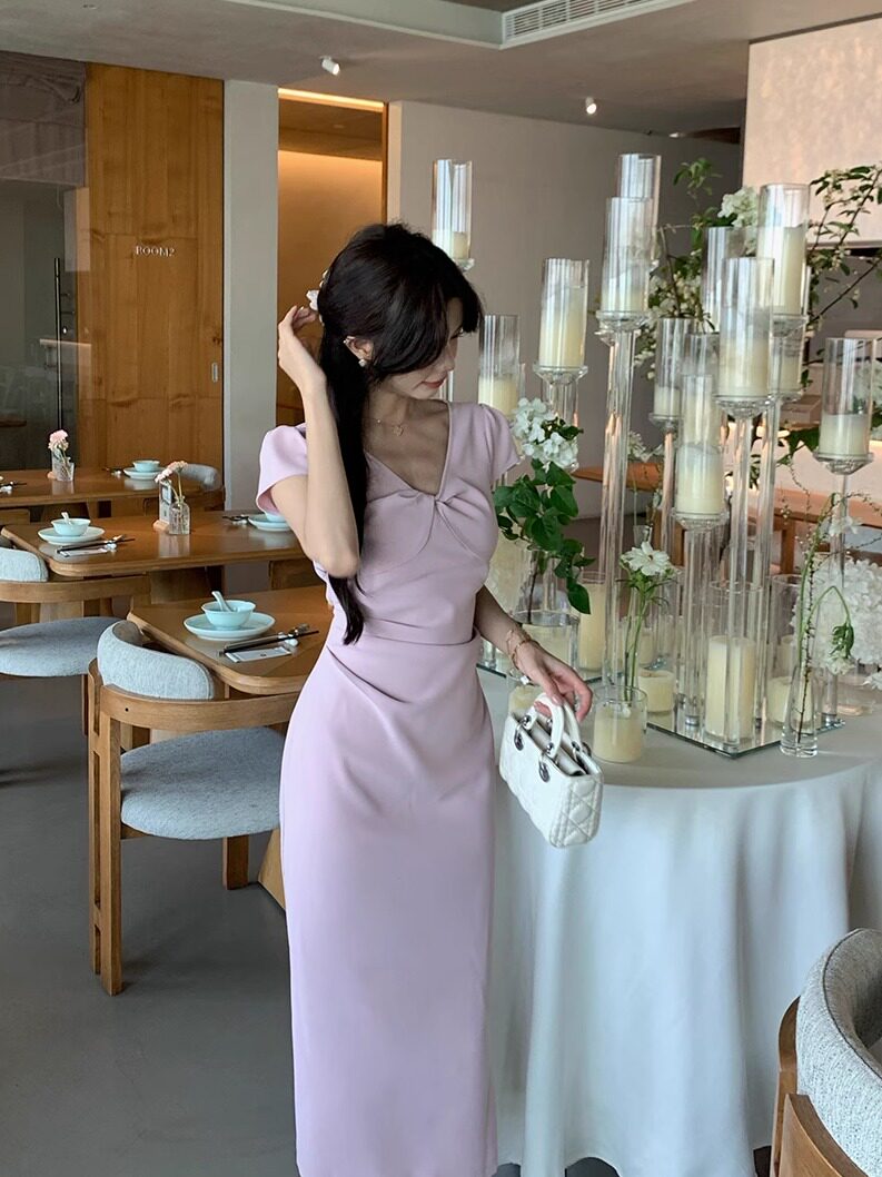 Woman wearing a lavender fitted dress in a restaurant setting