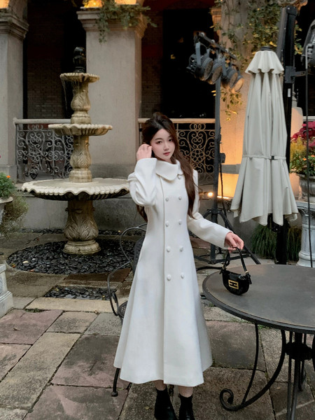 Woman wearing a white long double-breasted coat dress