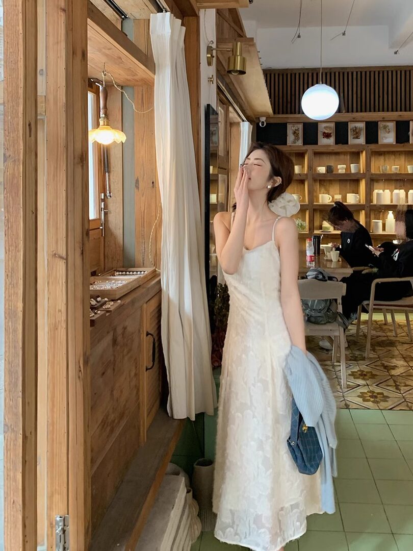 Woman wearing a white lace slip dress in a cafe