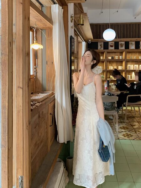 Woman wearing a white lace slip dress in a cafe