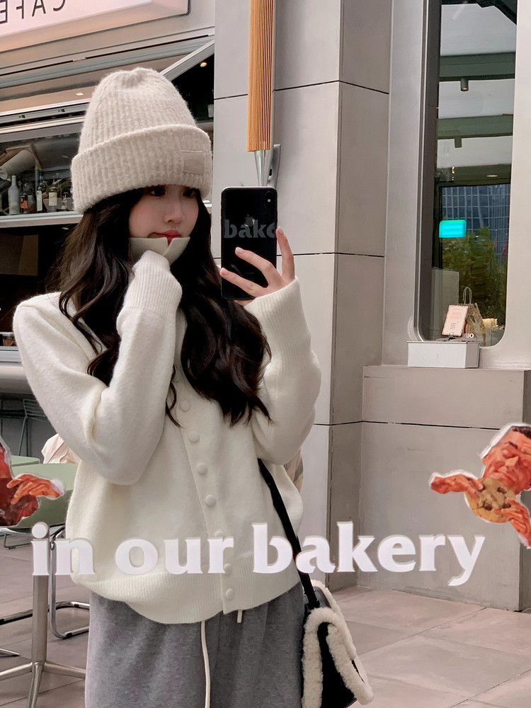 Woman wearing a white knit winter outfit and beanie
