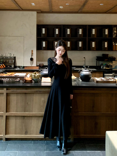 Black long-sleeve maxi dress worn by a model indoors