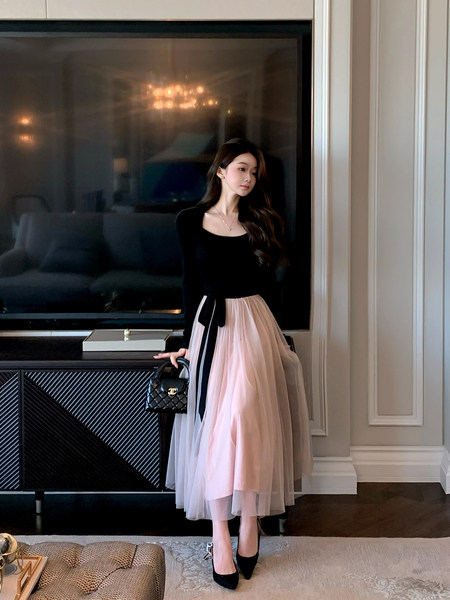 Woman modeling a black top with a pink tulle midi skirt and black heels