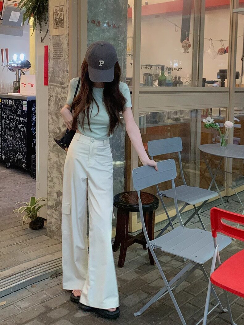 Woman wearing a mint short-sleeve top and white wide-leg pants