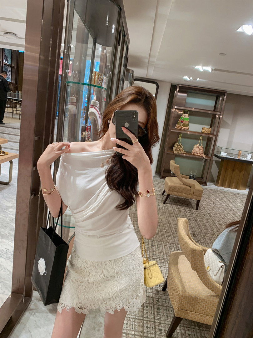 Woman wearing a white off-shoulder top with a lace mini skirt in a boutique mirror selfie
